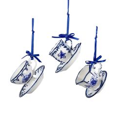 three tea cups hanging from strings with blue bows