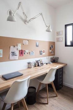 a desk with two chairs and a laptop on it