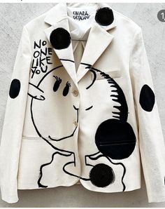 a white jacket with black polka dots on it and a cartoon character painted on the front