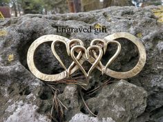 two wedding rings sitting on top of some rocks with the words engaged gift written above them