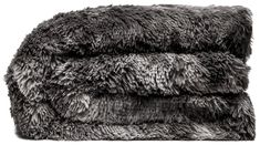 two gray fluffy blankets stacked on top of each other in front of a white background