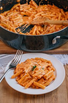 pasta with sauce and parmesan cheese in a skillet on a wooden table