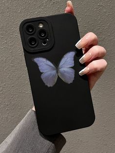 a woman's hand holding up a phone case with a blue butterfly on it