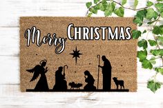 a door mat with the words merry christmas on it and silhouettes of nativity