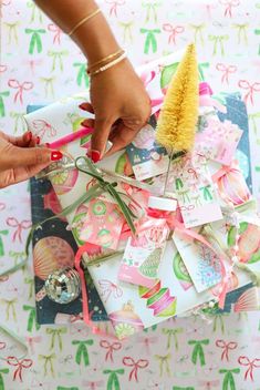 a person is holding a brush and some cards on a table with christmas decorations around it