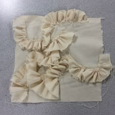 two pieces of cloth with ruffles on them sitting on top of a table