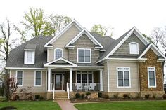 a large gray house with white trim and windows