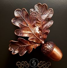 an oak leaf and acorn brooch on a black background with the number 8