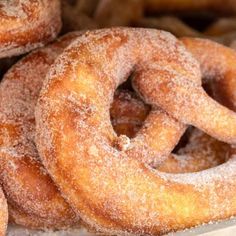 some sugared donuts are stacked on top of each other in a pile and ready to be eaten