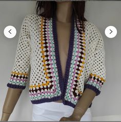 a mannequin wearing a crocheted jacket and white skirt with multicolored stripes