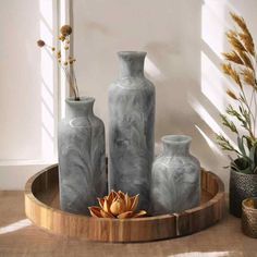 three vases sitting on top of a wooden tray