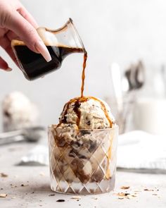 an ice cream sundae is being drizzled with caramel