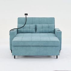 a blue couch sitting on top of a white floor next to a black corded light