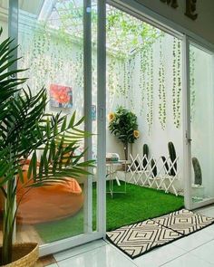 an indoor living area with artificial grass and potted plants on the side of the room