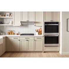 an image of a kitchen setting with white cabinets and stainless steel stove top ovens