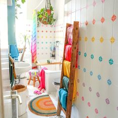 a bathroom with a ladder in the middle of it's wall and colorful rugs on the floor