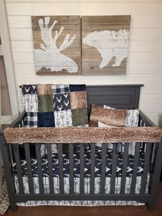 a baby crib with two paintings on the wall above it and pillows in front of it