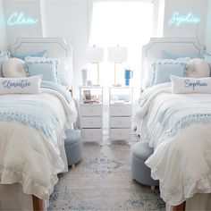 two twin beds with blue and white bedding in a bedroom next to a window