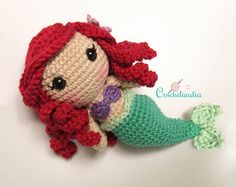 a crocheted little mermaid doll laying on the ground