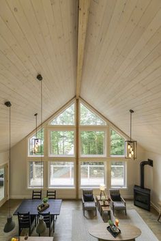 a living room filled with lots of furniture and large windows in the ceiling above it