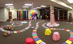 an indoor play area is decorated with brightly colored paper circles and streamers on the floor