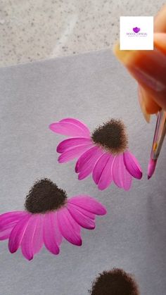 someone is painting two pink flowers on paper