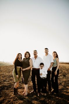 a family posing for a photo in the middle of an open field with no grass