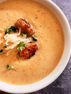 a white bowl filled with soup and meatballs