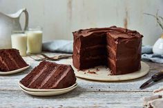 a chocolate cake with one slice cut out and the rest on plates next to it