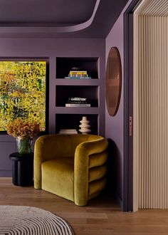 a living room with purple walls and yellow chairs