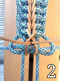 a close up of a blue and white rope attached to a wooden door with the number 2 on it