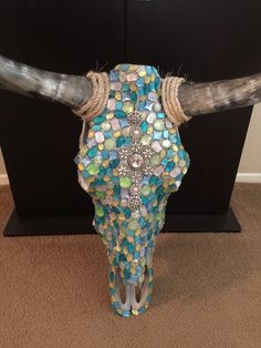 a cow skull decorated with jewels and beads