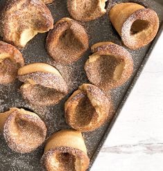 baked pastries on a baking sheet with powdered sugar