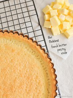 an uncooked pie sitting on top of a cooling rack next to some cheese