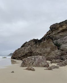 a large rock sitting on top of a sandy beach