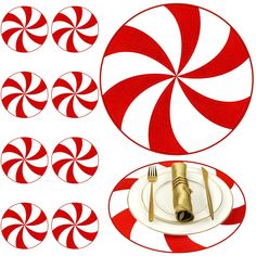 a table setting with red and white candy cane plates, silverware and napkins