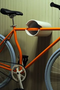 an orange bike with a cup holder attached to it