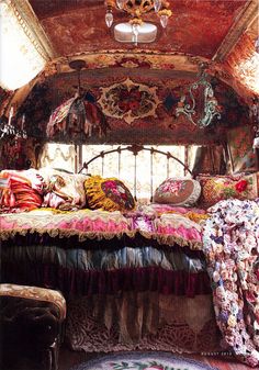 a bed in the middle of a room with lots of pillows and blankets on it