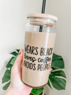 a person holding a coffee cup with the words, wear black loves coffee and avoid people