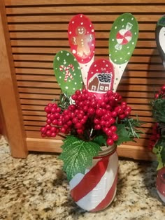 two christmas decorations sitting on top of a counter next to each other in vases