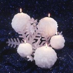 snowflakes and candles are arranged in the shape of a snowflake on a dark blue background