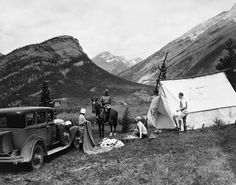 an old black and white photo of people camping in the mountains