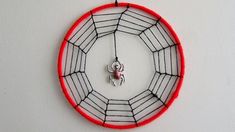 a clock made out of wire with a spider on it