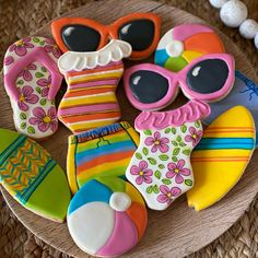 decorated cookies with sunglasses, flip flops and beach items on a wooden platter