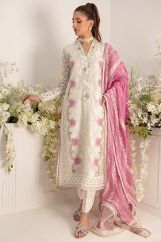 Design to shine on Eid festivities, this ensemble features stunning silk thread & applique work further enhanced with pearls, sequins & beadwork. Aari embroidered sleeves & side panels, stylish lace & embroidered border incorporated sleeves. This outfit is paired with hand Block printed statement and dupatta with lace & gota trims all over paired with straight pants with button details. Shirt Fabric: Pure Jacquard Silk net & embroidered Silk net Shirt Length: 48” (customisable, mention in order Embroidered Tissue Silk Kurta For Reception, White Tissue Silk Kurta For Diwali, White Silk Set For Reception, White Silk Sets For Reception, Embroidered Dola Silk Fabric For Straight Kurta, Embellished Raw Silk Traditional Wear For Eid, Elegant Embellished Embroidered Fabric For Festive Season, White Silk Traditional Designer Wear, Designer White Silk Traditional Wear