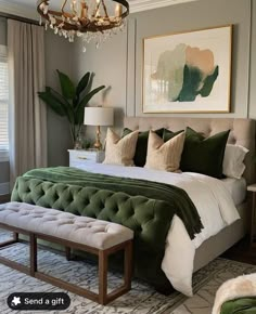 a bedroom with a large bed and green pillows on the headboard, along with a chandelier