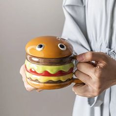 a woman is holding a hamburger shaped container