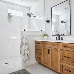 a bathroom with two sinks and a large mirror above the sink, along with a rug on the floor