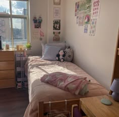 a bedroom with a bed, dresser and window in the corner that has pictures on the wall