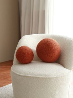 two orange balls sitting on top of a white chair